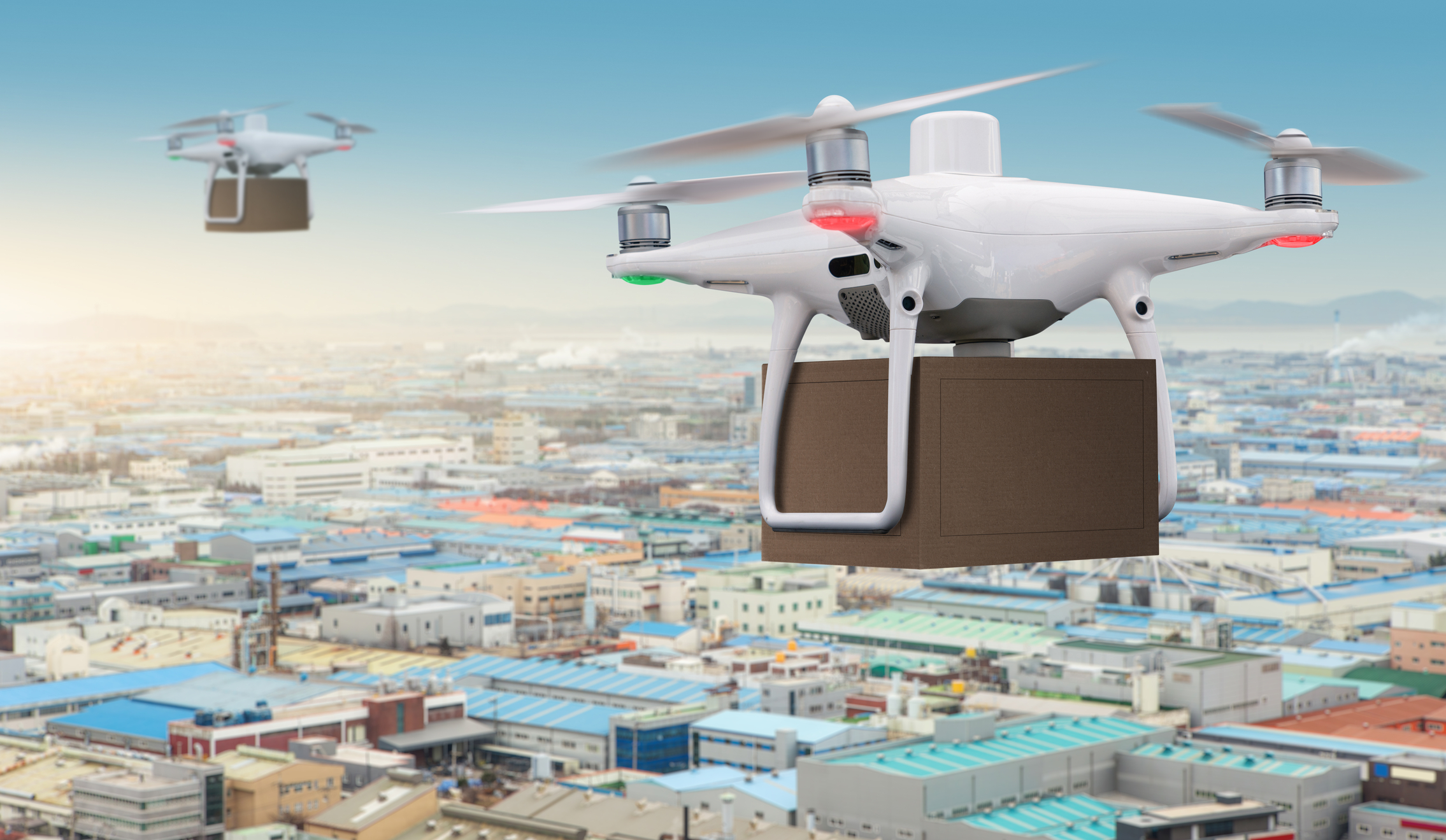 Drones with a packages flying under industrial park